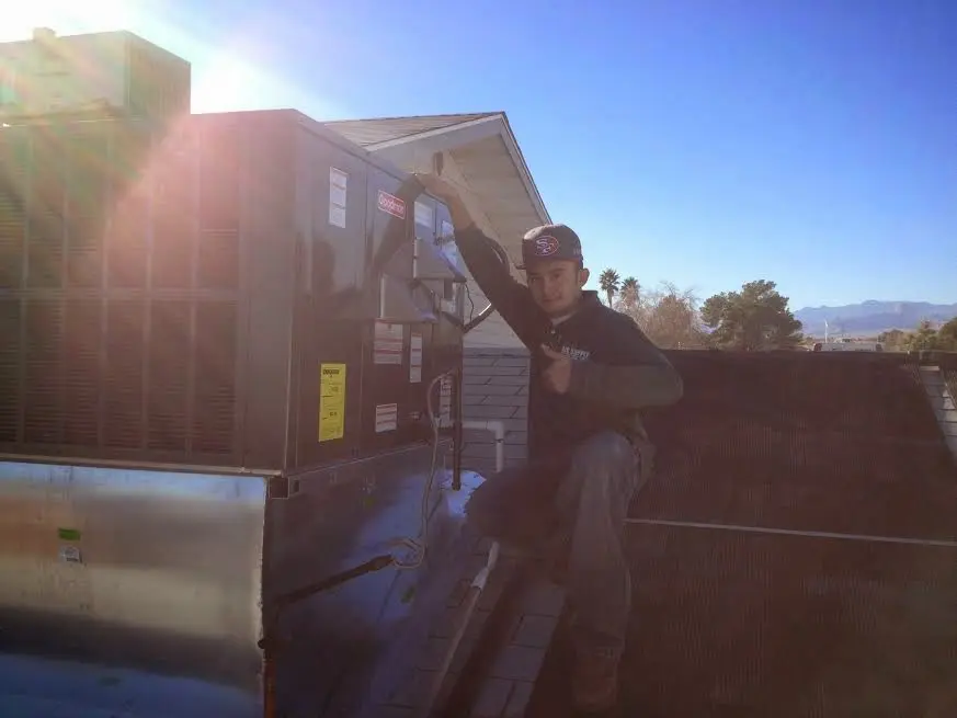 HVAC technician performing AC Tune-Up on a rooftop unit in Quincy